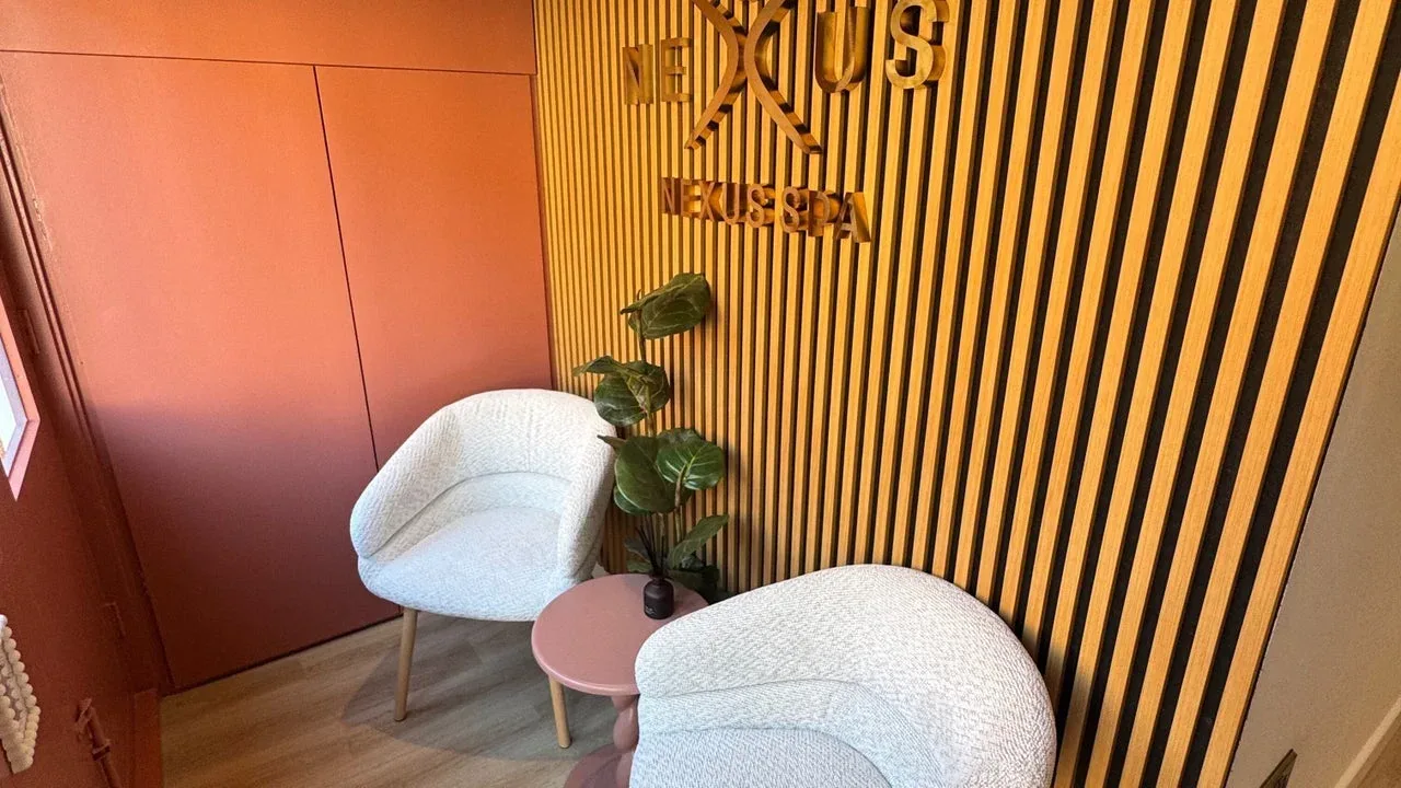 The Nexus Spa waiting lounge with soft chairs and timber panelling